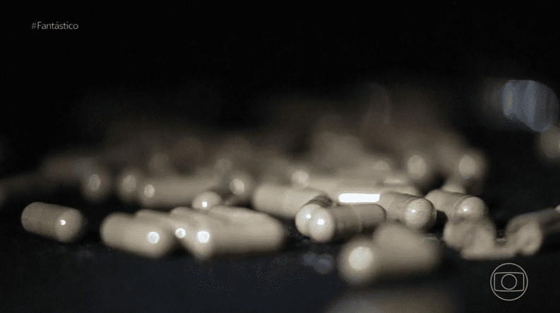 A imagem mostra a ilustração de cápsulas de remédio soltas em cima de uma mesa.