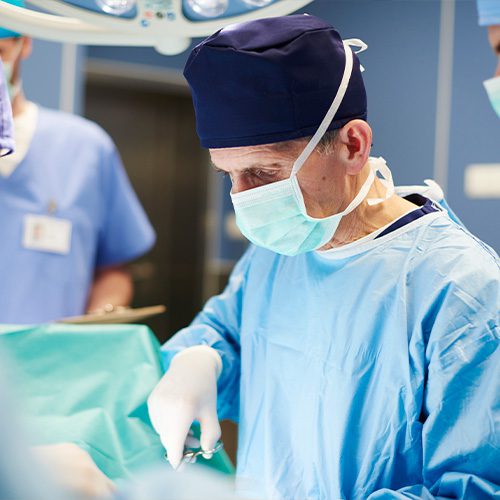 A imagem ilustra um médico cirurgião realizando um procedimento cirúrgico