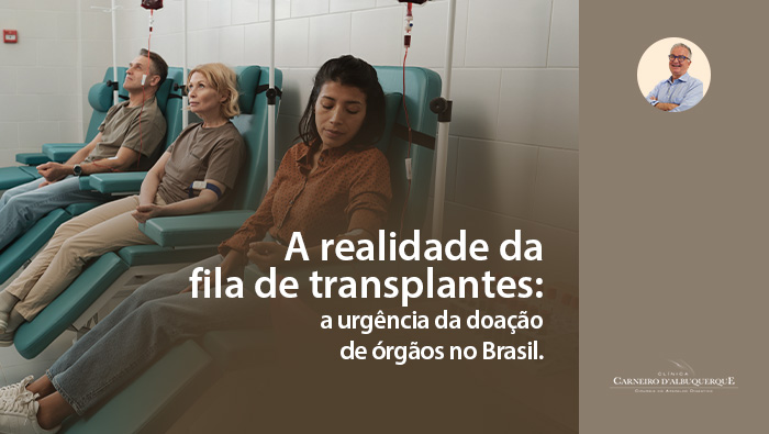 Três pessoas em cadeiras de infusão em um hospital, recebendo tratamento intravenoso, cada uma com bolsas de sangue conectadas, em um ambiente clínico.