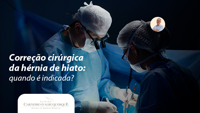 Cirurgiões realizando procedimento em sala de cirurgia, com vestimentas estéreis e iluminação direcionada na área operada.